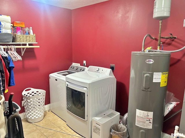 laundry area with tile patterned floors, washer and clothes dryer, and water heater