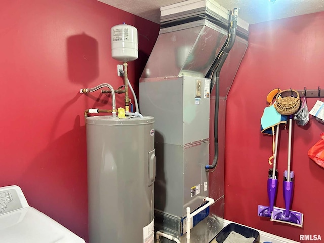 utility room with electric water heater and washer / clothes dryer