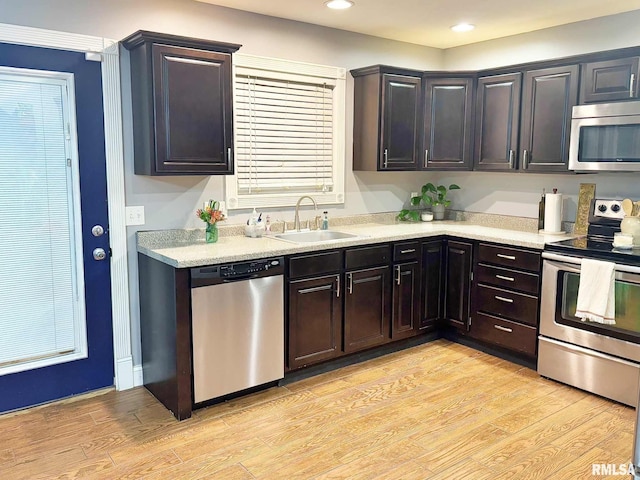 kitchen featuring dark brown cabinets, light hardwood / wood-style floors, sink, and stainless steel appliances