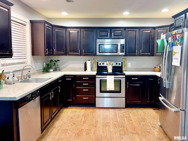 kitchen featuring stainless steel appliances, light hardwood / wood-style floors, and sink