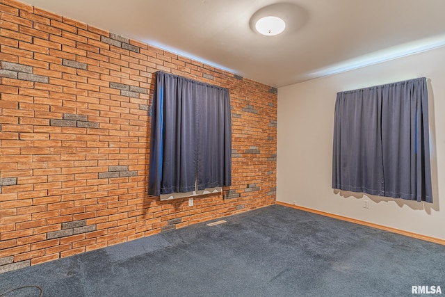 unfurnished room with brick wall and carpet