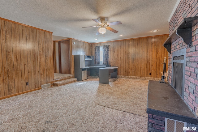 kitchen with ceiling fan, wooden walls, and a textured ceiling