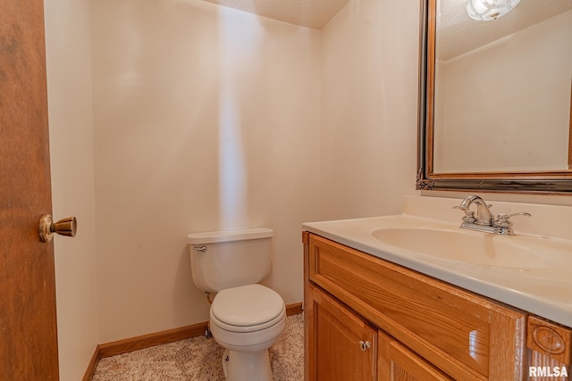 bathroom with vanity, a textured ceiling, and toilet