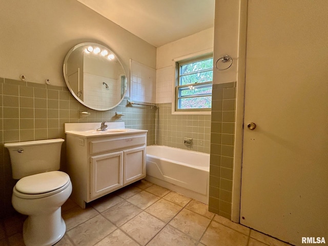 bathroom with tile patterned flooring, vanity, a bath, toilet, and tile walls