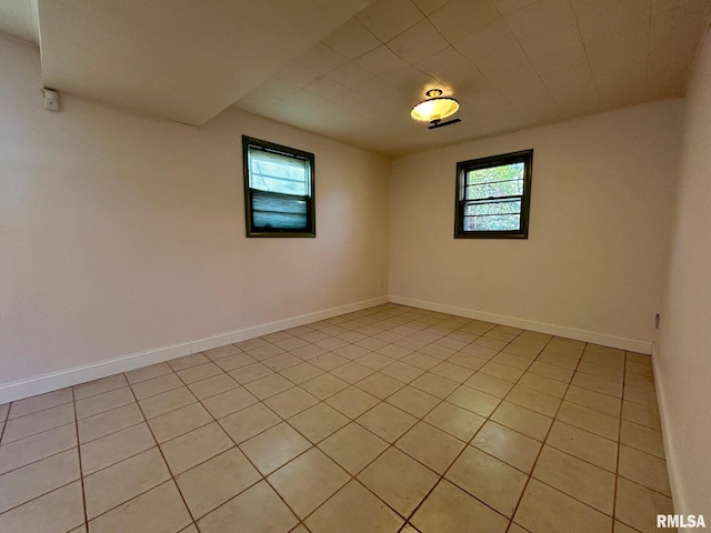 spare room featuring plenty of natural light and light tile patterned flooring