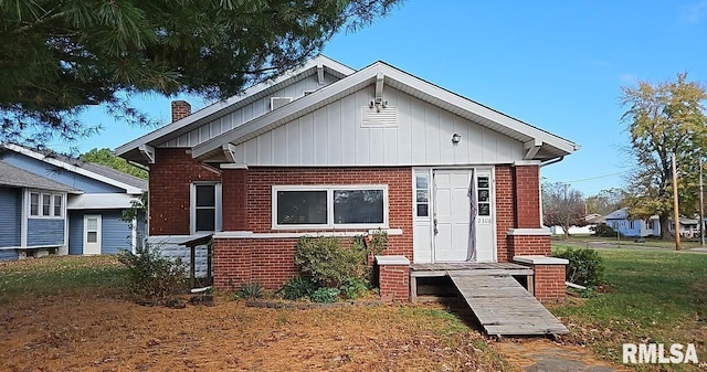 bungalow-style home with a front yard