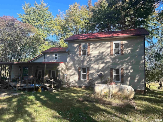 back of property with a lawn and a deck