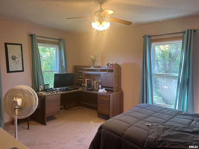 carpeted bedroom featuring a textured ceiling and ceiling fan