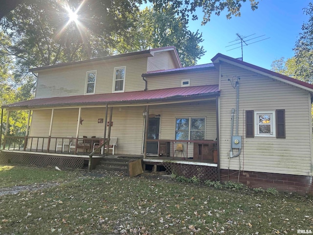 rear view of property with a yard and covered porch