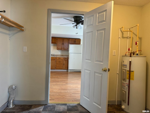 interior space with sink, ceiling fan, a textured ceiling, dark wood-type flooring, and water heater