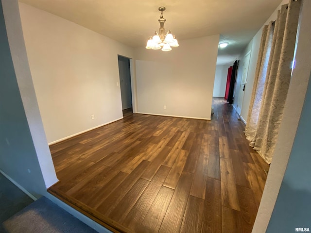 unfurnished dining area with dark wood-type flooring and a chandelier