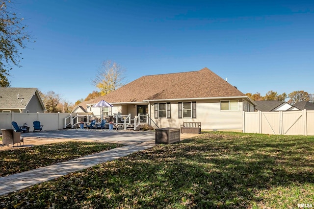 rear view of house featuring a yard and a patio