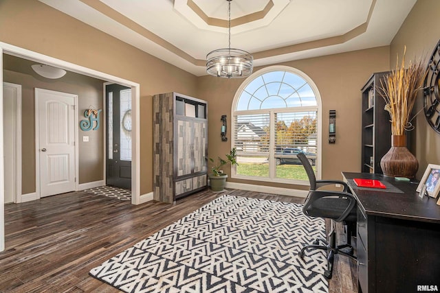 office with dark hardwood / wood-style floors, an inviting chandelier, and a tray ceiling