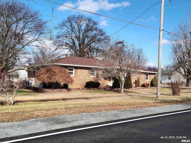 ranch-style house featuring a front lawn and brick siding