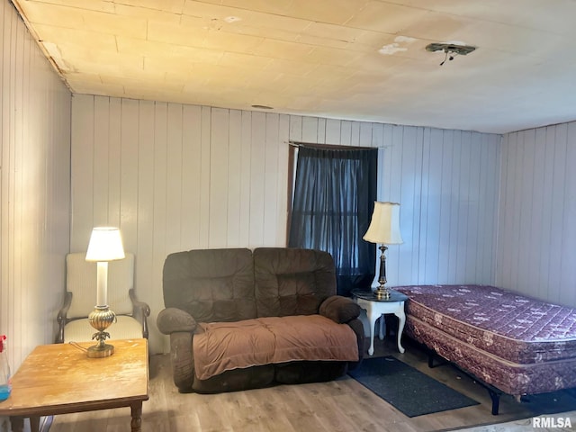 interior space with hardwood / wood-style flooring and wooden walls