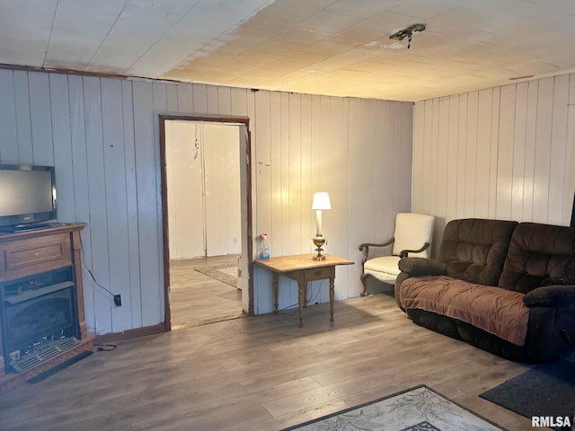 living room featuring light hardwood / wood-style floors and wooden walls