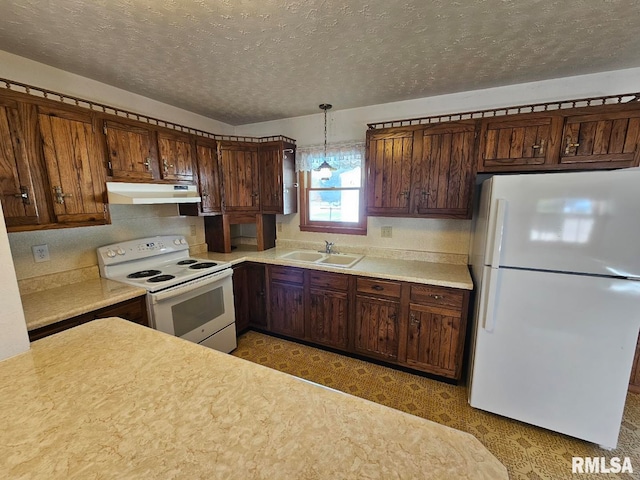 kitchen featuring sink, a textured ceiling, decorative light fixtures, white appliances, and a notable chandelier