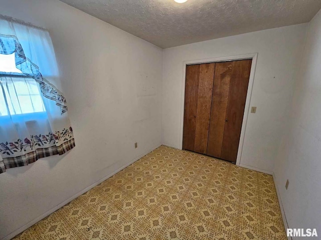 unfurnished bedroom with a textured ceiling and a closet