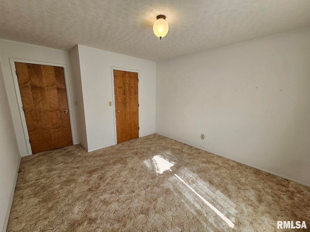 unfurnished bedroom with a closet, a textured ceiling, and carpet floors