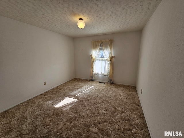 unfurnished room with a textured ceiling and carpet