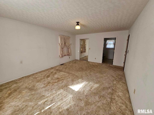 carpeted spare room featuring a textured ceiling