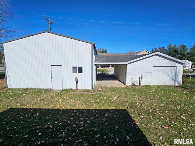 view of outdoor structure featuring a garage and a lawn