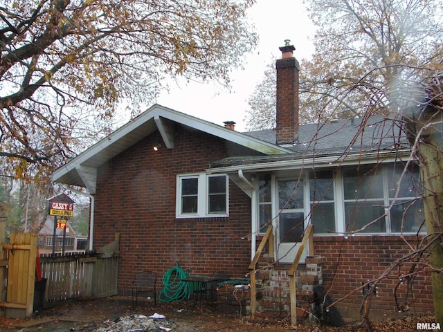 rear view of house featuring a sunroom