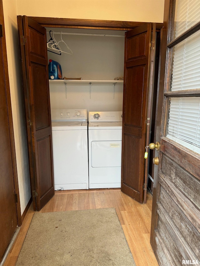 laundry area with washing machine and dryer and light hardwood / wood-style floors