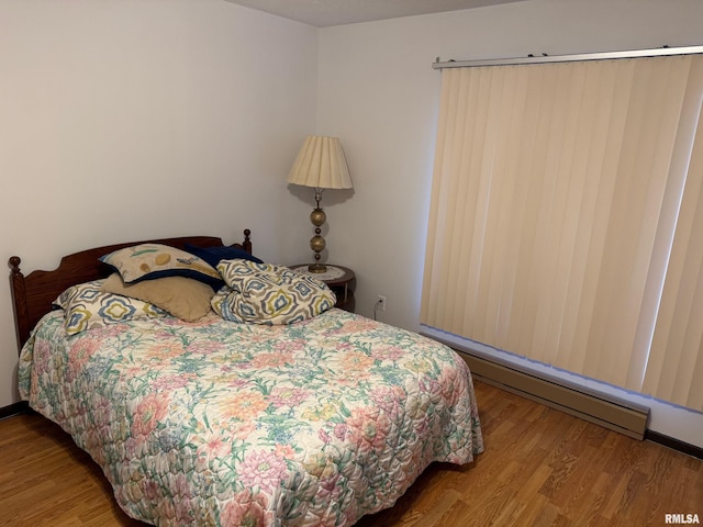 bedroom featuring hardwood / wood-style floors and baseboard heating