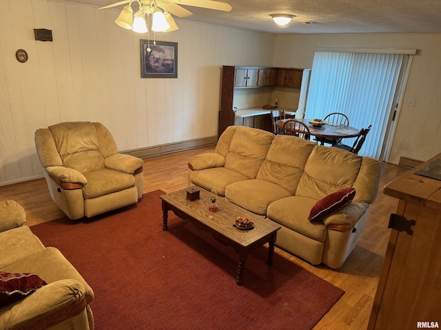 309 E Gelston St, Valier, IL 62891 - living area with a baseboard heating unit, light wood-style flooring, and a ceiling fan