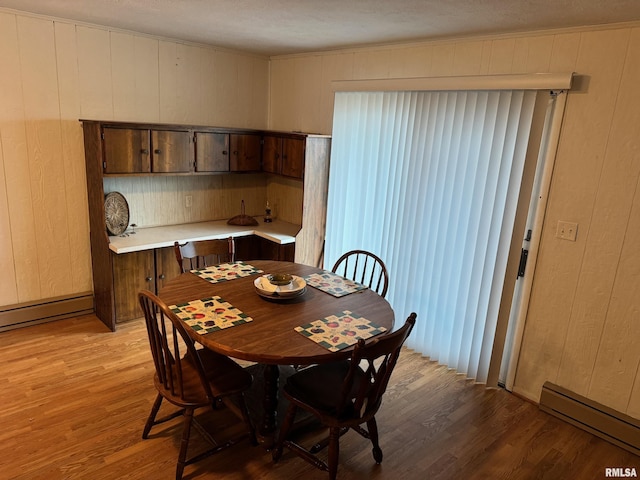 309 E Gelston St, Valier, IL 62891 - dining space with baseboard heating, light wood finished floors, crown molding, and wooden walls