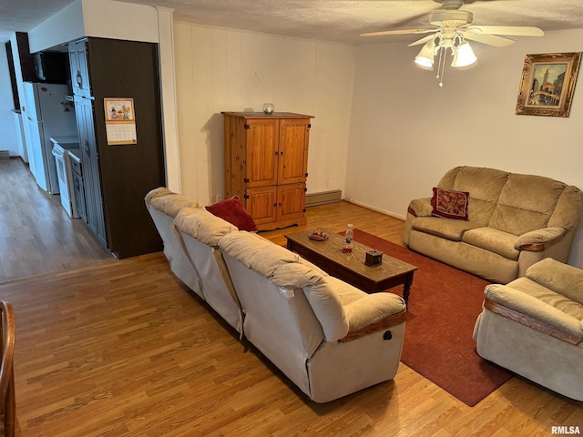 living room featuring ceiling fan, wood-type flooring, and a textured ceiling