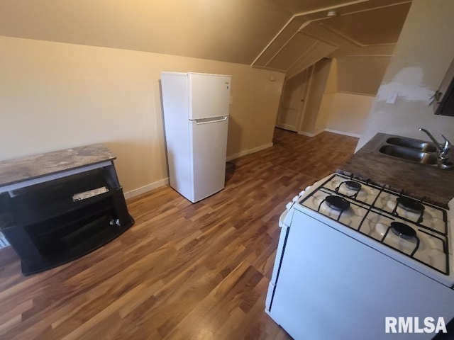 kitchen with vaulted ceiling, sink, wood-type flooring, and white appliances