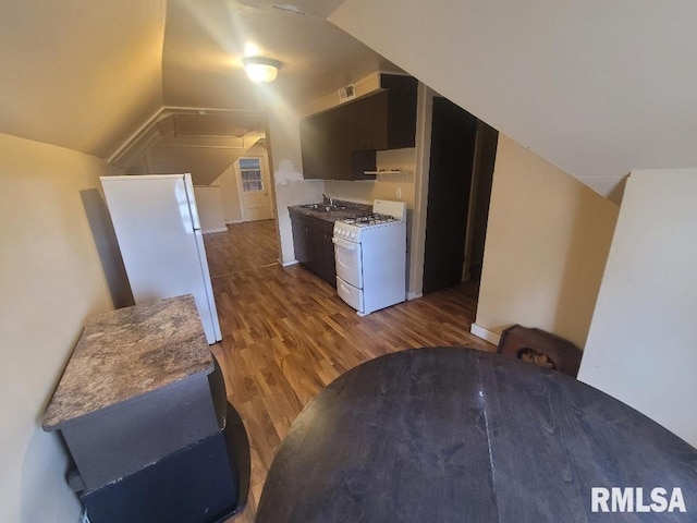 kitchen featuring lofted ceiling, dark hardwood / wood-style flooring, white appliances, and sink