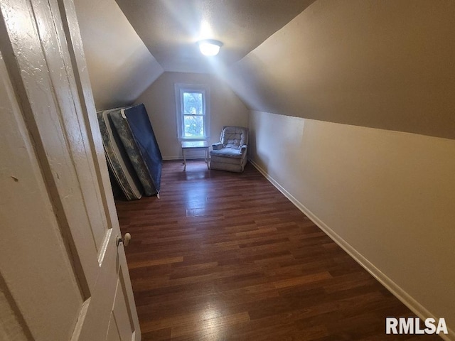 additional living space with dark hardwood / wood-style flooring and vaulted ceiling