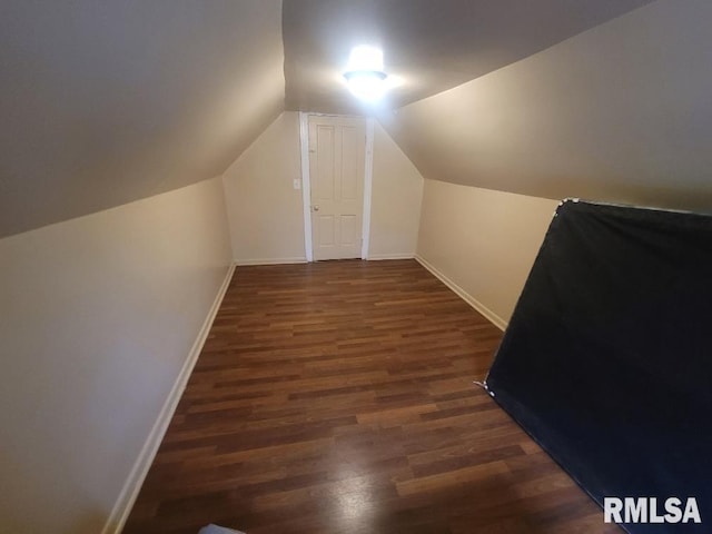 additional living space featuring dark hardwood / wood-style flooring and vaulted ceiling