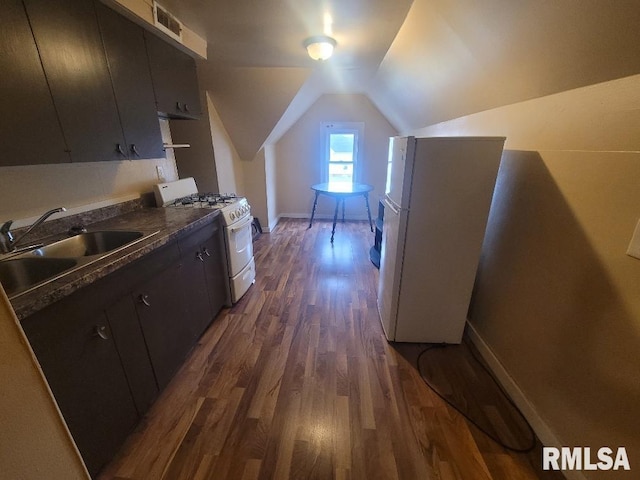 300 S Locust St, Mcleansboro, IL 62859 - kitchen featuring white appliances, dark wood-style floors, dark countertops, vaulted ceiling, and dark cabinets