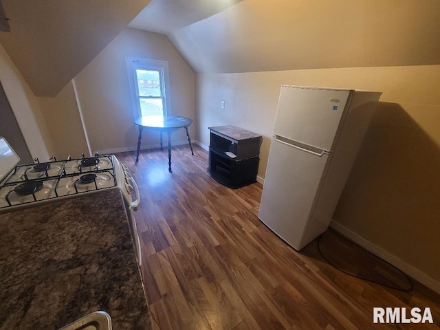 interior space featuring vaulted ceiling, dark hardwood / wood-style floors, and white appliances