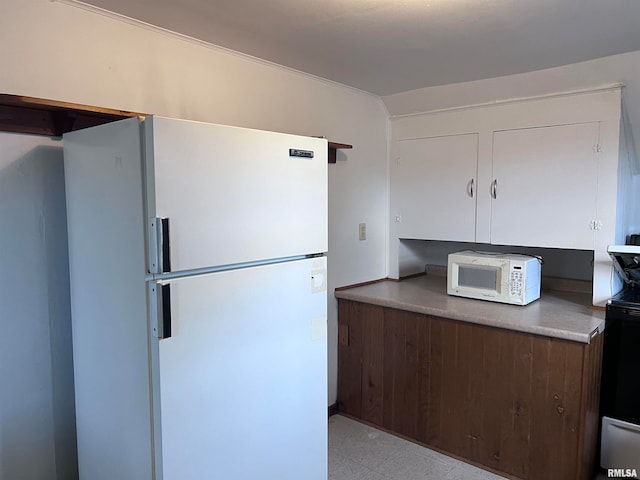 kitchen with dark brown cabinets and white appliances