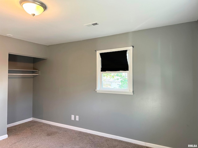 unfurnished bedroom featuring carpet floors and a closet