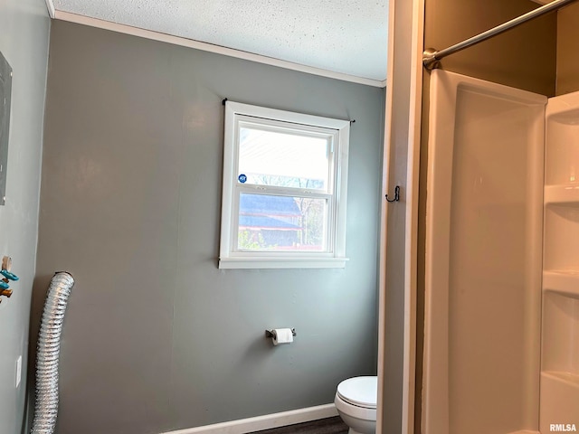 bathroom with a textured ceiling, toilet, and walk in shower