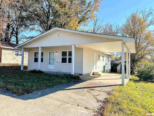 view of front of property with a carport, a porch, and a front lawn