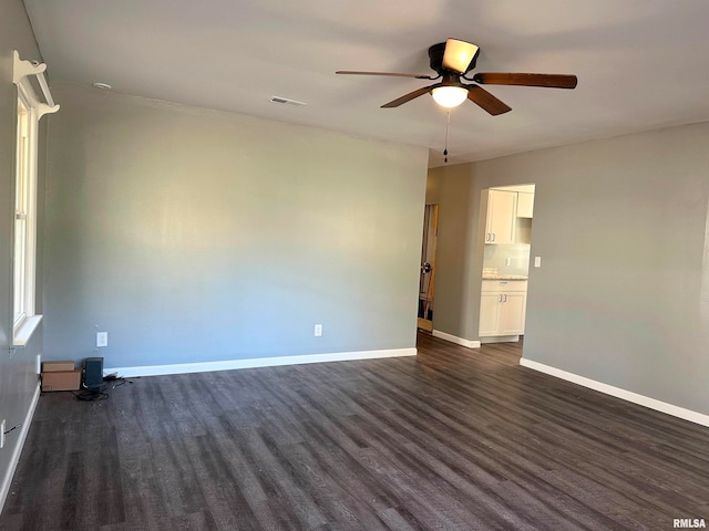 empty room with dark hardwood / wood-style floors and ceiling fan