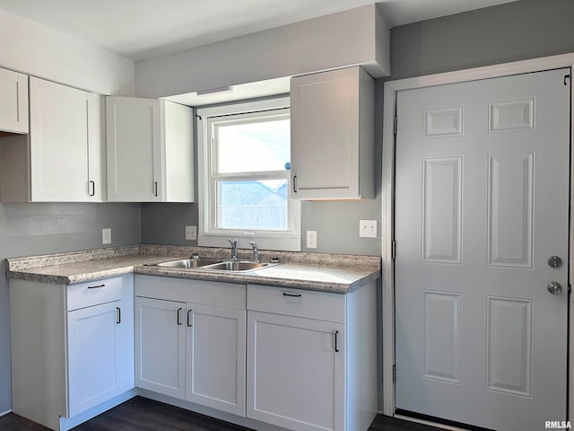 kitchen featuring white cabinets, dark hardwood / wood-style flooring, and sink