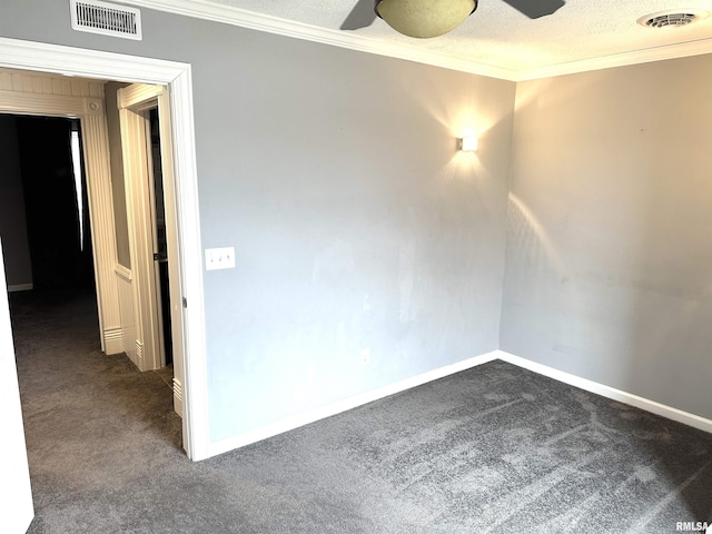 spare room featuring ceiling fan, dark carpet, ornamental molding, and a textured ceiling