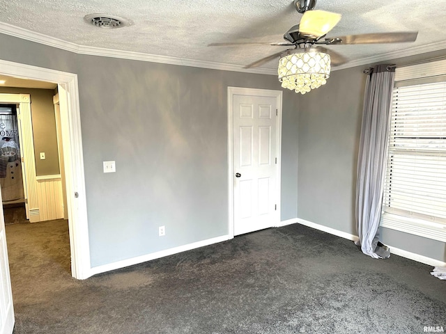 unfurnished room featuring ceiling fan, dark carpet, a textured ceiling, and ornamental molding