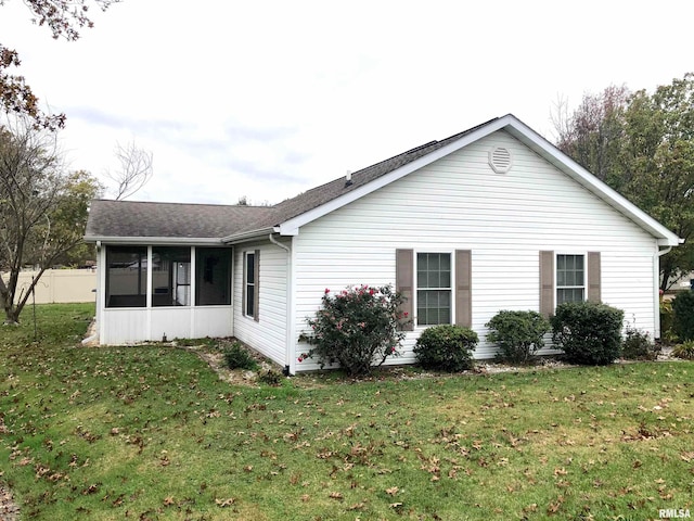 view of home's exterior with a yard and a sunroom