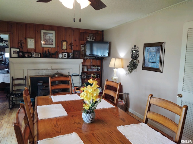 20366 Noisy Goose Ln, Olive Branch, IL 62969 - dining room with wood-type flooring, ceiling fan, a fireplace, crown molding, and baseboards