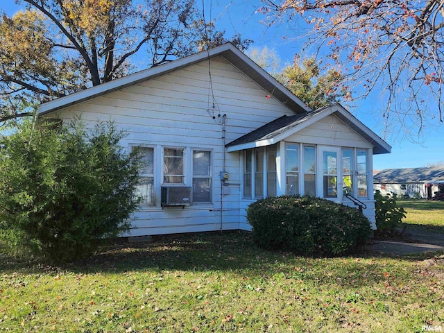 view of front of property featuring a front lawn and a sunroom