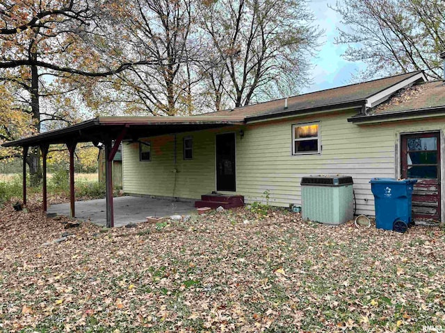 rear view of property featuring a carport, a patio, and central AC unit